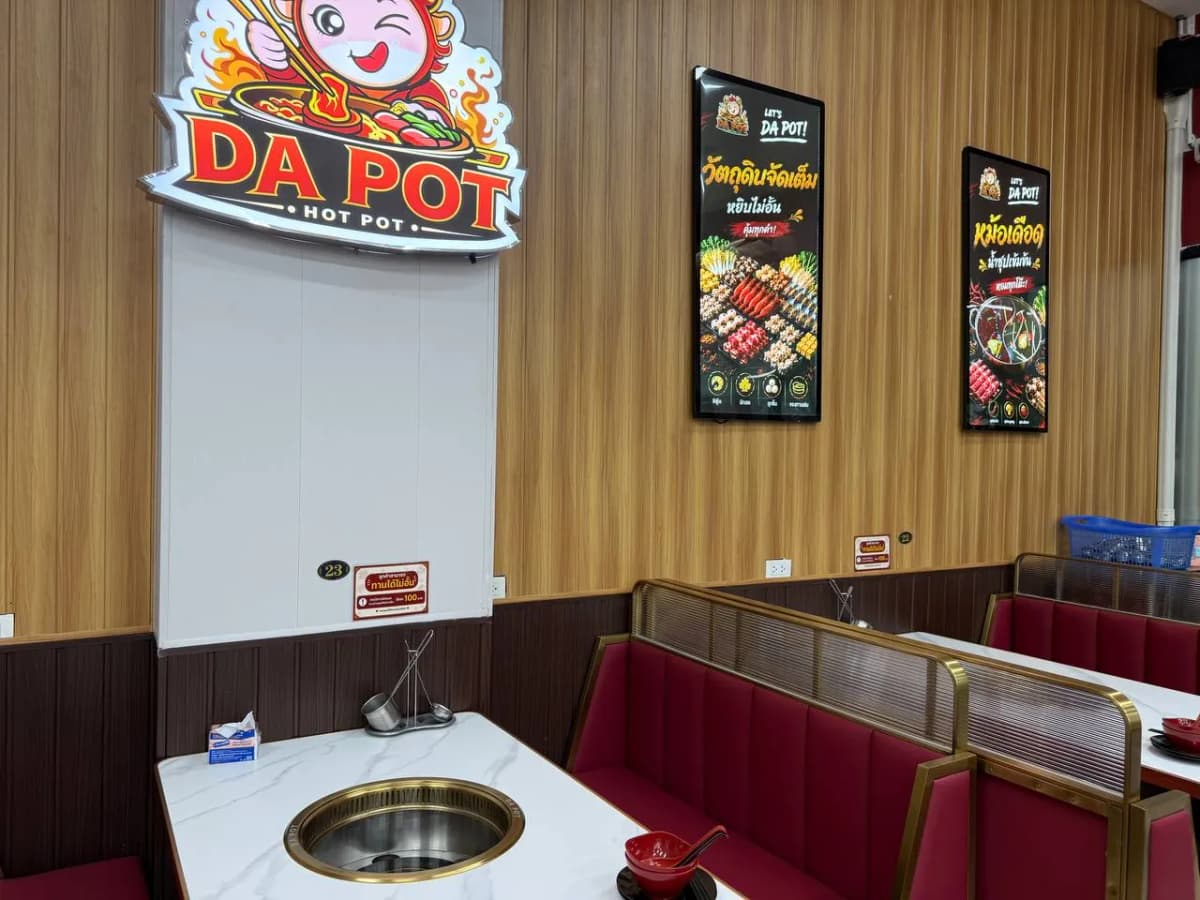 ที่นั่งโซฟาแดงใต้ป้าย DA POT